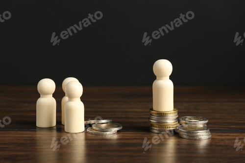 Preview: Financial inequality. Wooden figure with more coins than others on table