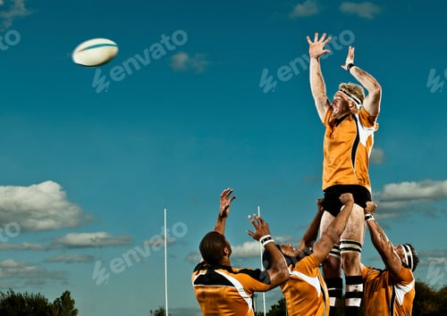 Preview: Rugby players reaching for the ball during a lineout under a clear blue sky
