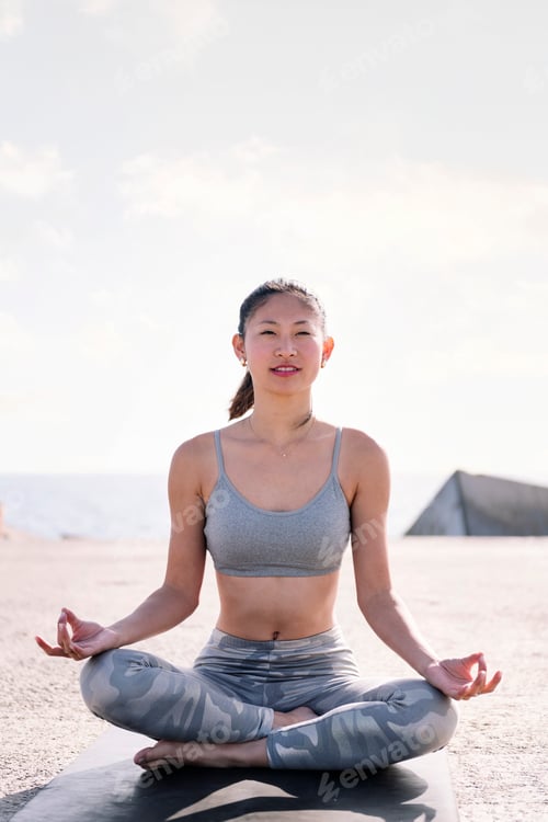 Preview: woman doing yoga meditation sitting by the sea