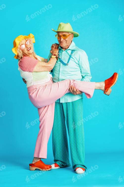Preview: Beautiful senior old couple wearing fancy party clothes acting in studio on a colored background.