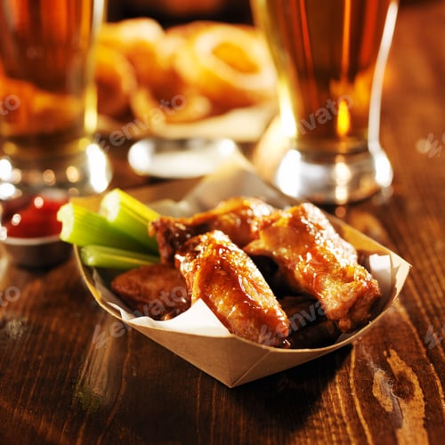 Preview: barbecue buffalo chicken wings served with beer, celery, and ranch