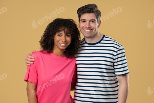 Preview: Smiling interracial couple, young black woman white man bonding on beige studio.