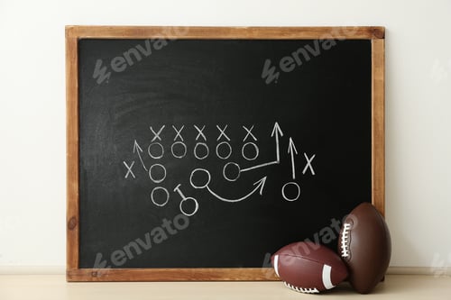 Preview: Rugby balls near chalkboard with football game scheme on table