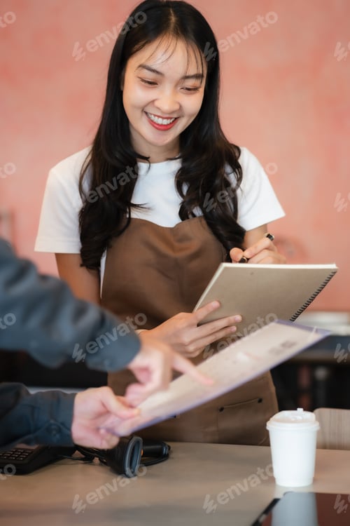 Preview: Asian female barista wear apron at counter bar with smile face, cafe service concept