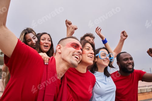 Preview: A group of people of different races and ages follow the soccer game in the stands.