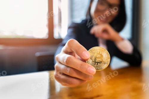 Preview: Golden bitcoin (cryptocurrency) in hand of businesswoman. New Virtual money concept
