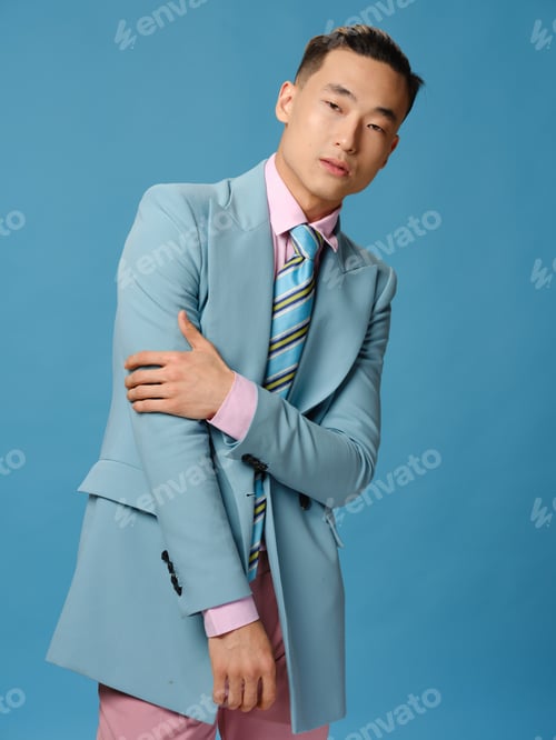 Preview: A man in a jacket and a pink shirt on a blue background pants cropped view