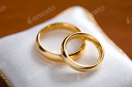 Preview: closeup of engagement rings, wedding, on a cushion