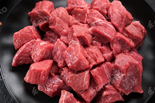 Preview: Raw chopped beef meat. Raw organic meat beef or lamb, spices, herbs on black plate on dark grey conc