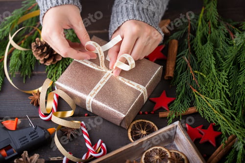 Preview: Woman hands making Christmas day gifts.