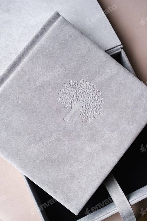 Preview: A photo book in a grey cloth cover lies on the box. the concept of creating books