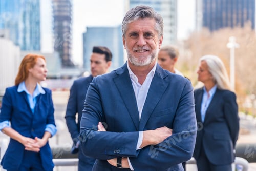 Preview: Caucasian businessman in a professional suit stands in front of a group of businesspeople