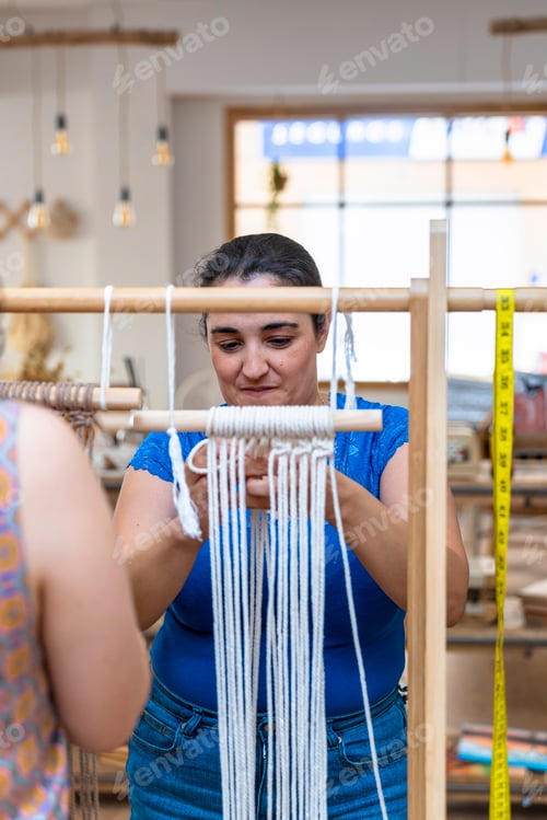 Preview: Middle aged woman making macrame in a workshop