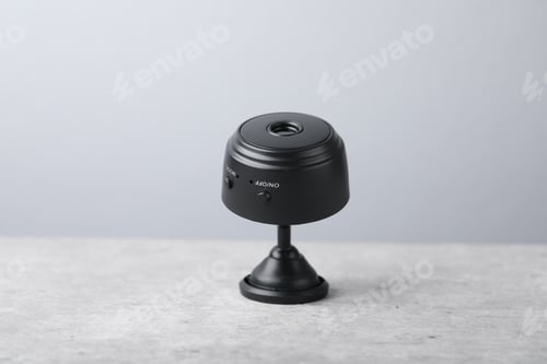 Preview: Modern hidden spy camera on light grey table, closeup