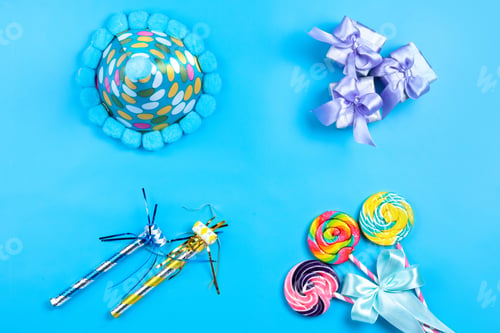 Preview: a top view little gift boxes along with colorful lollipops birthday whistles and funny cap on the