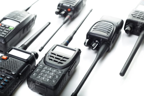 Preview: Various models of walkie talkies arranged on a white surface for technology showcase in