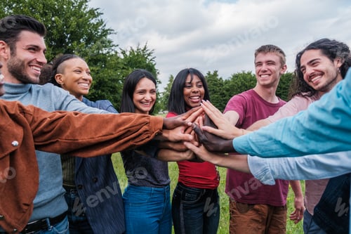 Preview: Group of young people joining hands to join forces and work as a team