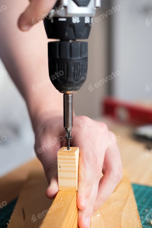 Preview: Drive a screw into wood with an electric screwdriver. The theme of craft and woodworking