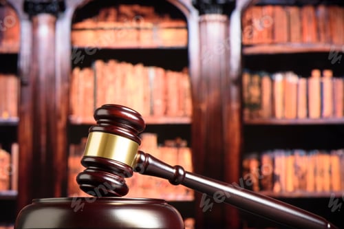Preview: Close up of wooden judge gavel. Blury book library background