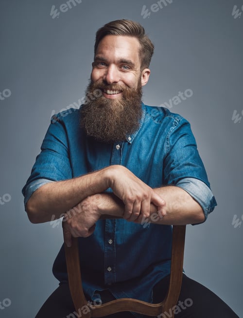 Preview: Laughing man with arms on back of chair over gray
