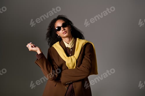 Preview: Confident African American woman showcases stylish autumn fashion in a studio
