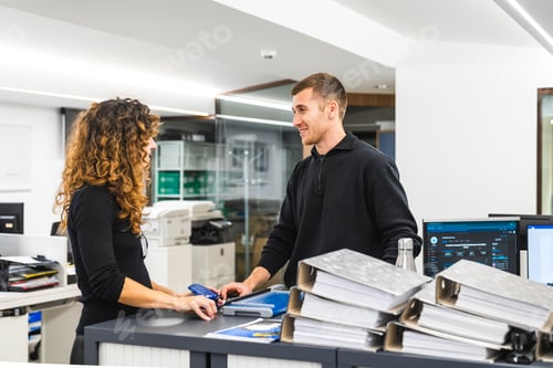 Preview: Friendly Colleagues Chatting at the Reception Desk in Office