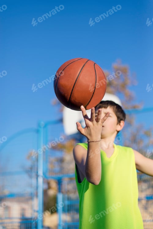 Preview: Teenager playing basketball on an outdoors court