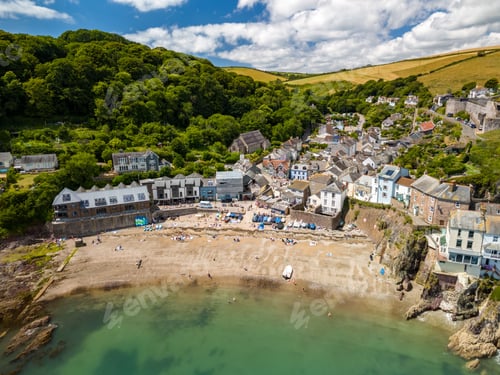 Preview: a coastal village with a sandy beach and lush green hills in Cornwall, England