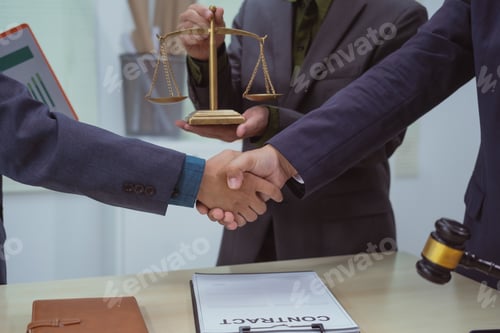 Preview: Three lawyers in a meeting at the table in an office, shaking hands discussing business, focusing