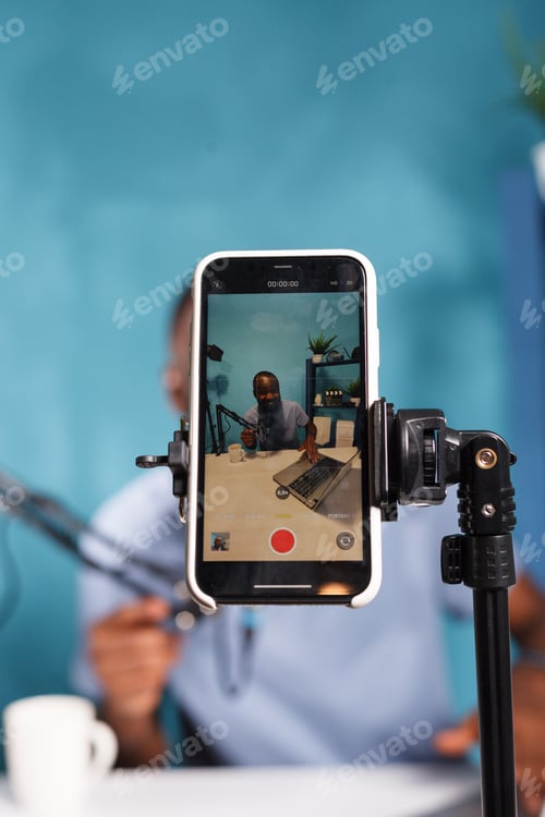 Preview: Blogger on phone screen using laptop