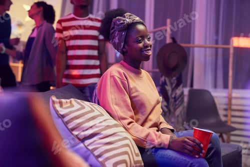 Preview: Woman Relaxing on a Couch at a Party
