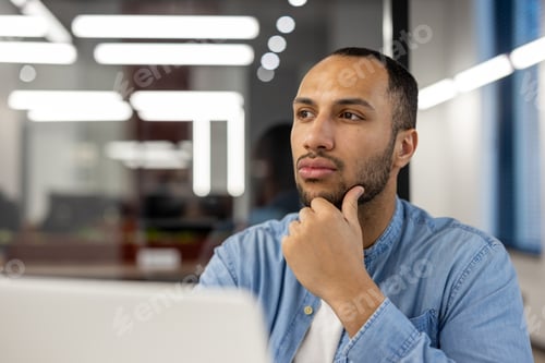 Preview: Thoughtful professional in a modern office setting looking into the distance