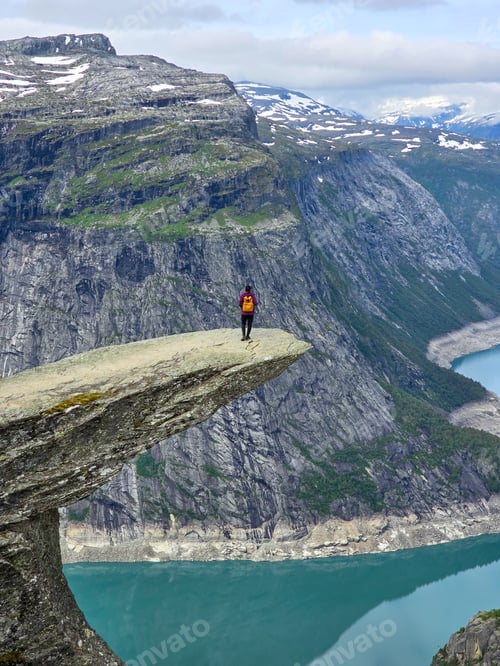 Preview: Trolltunga, Norway, Hiker Standing on a Precarious Cliff Overlooking Norway's Majestic Fjord