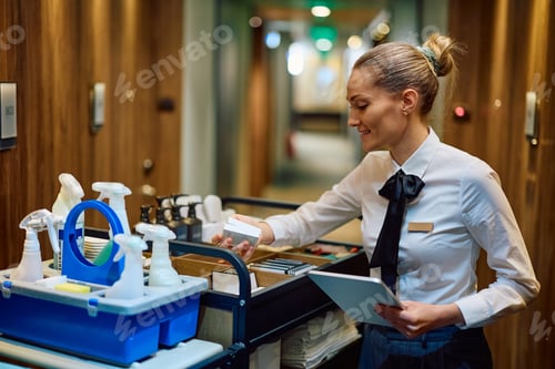 Preview: Housekeeping manager checking supplies in chambermaid's trolley in a hotel.