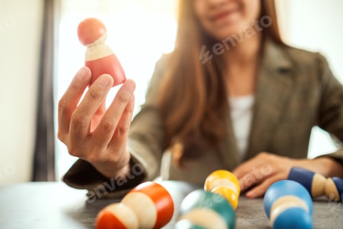 Preview: Businesswoman leader choosing wooden people from a group of employees in office