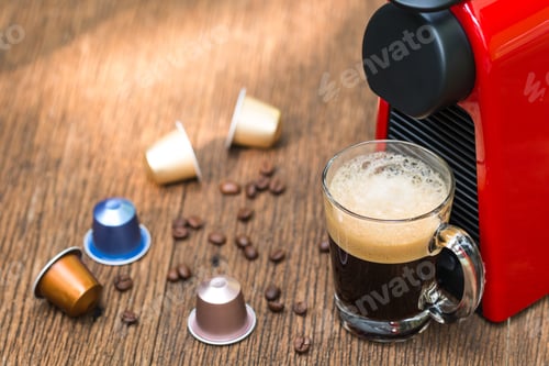 Preview: Espresso coffee machine with capsules making black coffee in a glass cup on the wooden table and