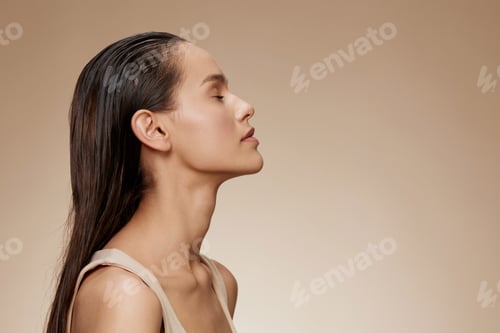Preview: Profile portrait of a serene woman with long, wet hair against a neutral background, showcasing