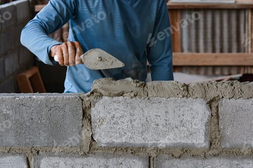 Preview: Bricklayer laying bricks on mortar