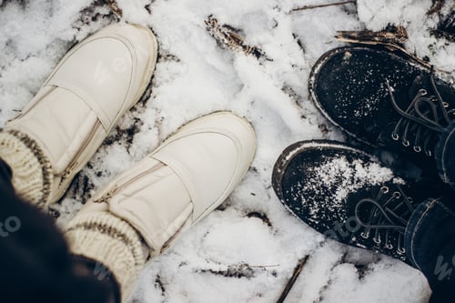 Preview: view from top at couple shoes in snow on ground in winter park