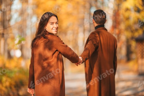 Preview: Happy family walking in autumn park on sunny fall day