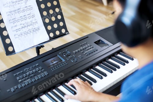 Preview: Shoulder View of Man Playing Piano While Looking the Sheet Music at Home