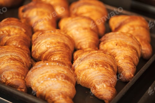 Preview: Close up of tray of freshly baked croissants in a bakery.