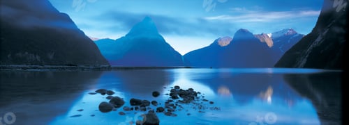 Preview: Landscape with lake surrounded by mountains at dusk.