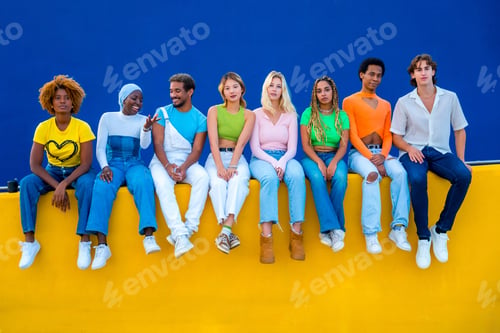 Preview: Young people with colorful clothes sitting on a colorful wall