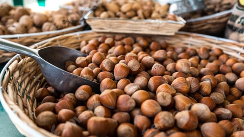 Preview: Closeup shot of a basket of hazelnut with metal scoop in a market setting