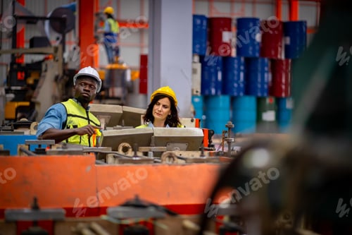 Preview: Team male and female engineers in a metal sheet factory