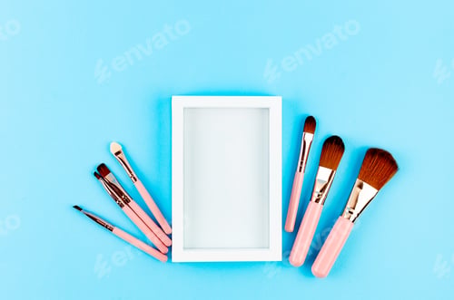 Preview: Various Makeup Brushes pink set with place for text on blue paper Background,
