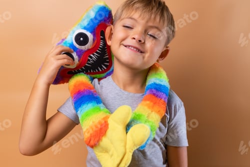 Preview: Positive little boy 6 years old with a bright colored toy. Concept: kindergarten, imaginary friend