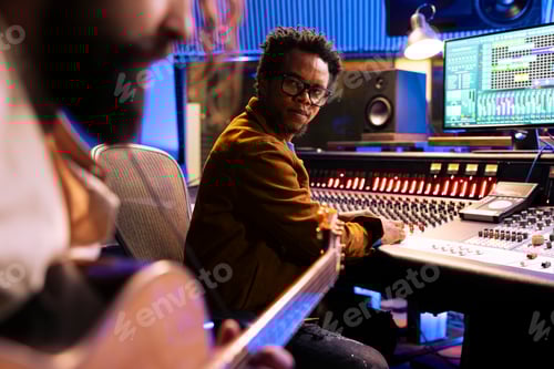 Preview: Young musician playing electro acoustic guitar and recording tunes in studio