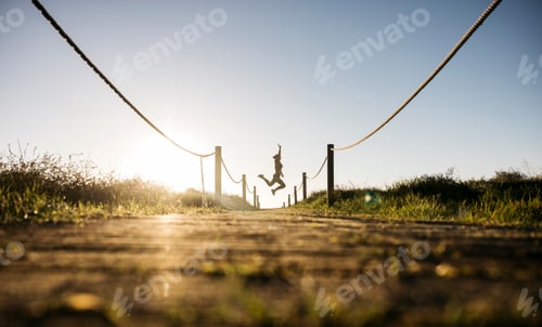 Preview: Woman jumping celebrating freedom outdoors at sunset